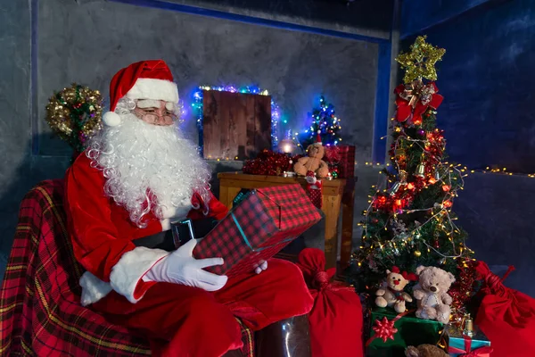 Santa Claus Segurando Caixa Presente Casa Sente Cadeira Pensar Sobre — Fotografia de Stock