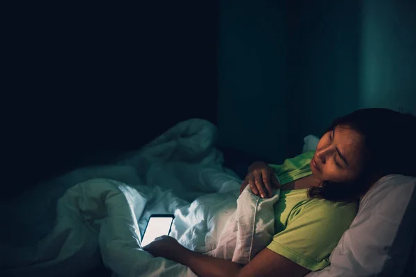 Asian woman play smartphone in the bed at night,Thailand people,Addict social media,Play internet all night