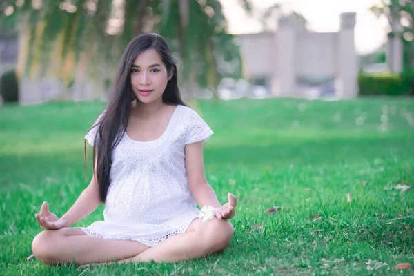 年轻孕妇在公园里做瑜伽的肖像 泰国人 — 图库照片