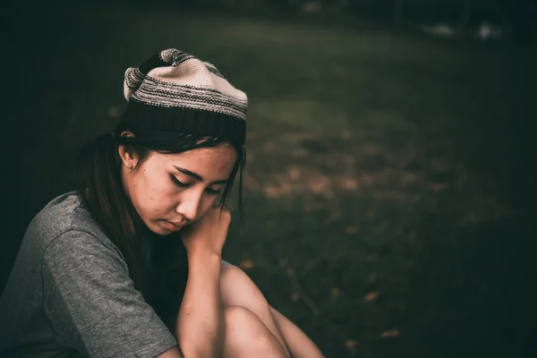 孤独なアジアの女性が一人で公園に座って 悲しいタイの女性は何かを考えて ハートブレイクの女の子のコンセプト — ストック写真