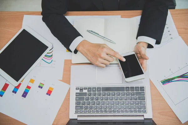 Asian businessman working on the desk with laptop,tablet,and smart phone from top view,Modern thai guy work in office,high angle of employee sitting for work in a company