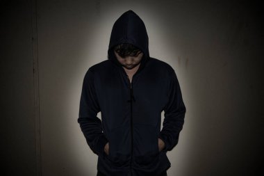 Asyalı üzgün bir adamın portresi, kapüşonlu bir uyuşturucu bağımlısı, flakka uyuşturucu, zombi ilacı, koyu renk
