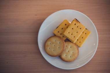 Beyaz tabak üzerinde beyaz kraker ahşap masa, klasik tarz, koyu ton, film, pastel, seçici odak