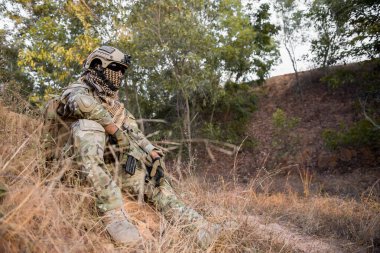 Ormanda eli silahlı Asyalı asker, manevra için hazırlan, eski askerler konsepti.