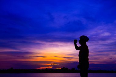 Gün batımında bisikletli Asyalı yakışıklı bir siluet.