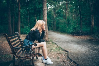 Bankta oturan üzgün kadın parkın arka tarafından klasik tarzda, hikayeyi çok daha kötü anlattı, thailand insanlar