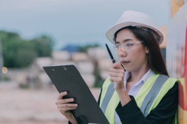 Tayland 'da büyük bir inşaat projesinin şantiyesinde çalışan Asyalı mühendis inşaat alanında fazla mesai yapıyor.