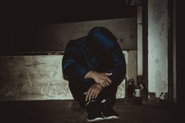 Asyalı üzgün bir adamın portresi, yerde oturan uyuşturucu bağımlısı, flakka ilacı, zombi uyuşturucusu