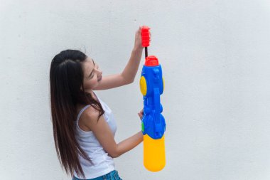 Beyaz arka planda su tabancası olan Asyalı kadın Tayland 'da Şenlik Songkran Günü