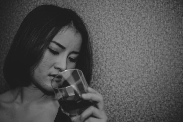 Asian woman broken heart with whiskey in hand on vintage style,she heart break from love,sad woman concept