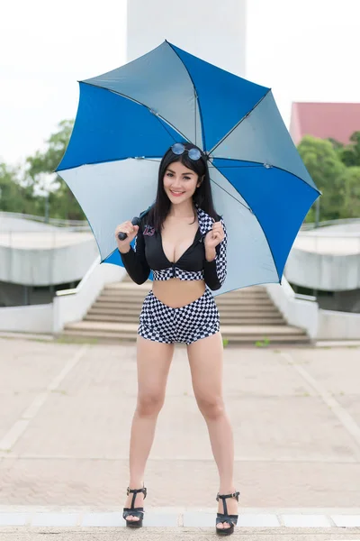 Beautiful asian sexy woman in black dress with umbrella outdoor,Pretty thailand racing dress style portrait