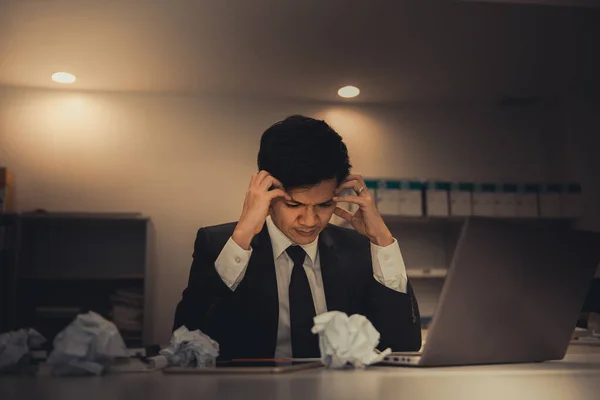 Businessman stress from hard work on the desk at office dark tone