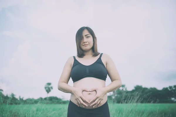 妊娠中の女性の手の心であなたの腹 ヴィンテージスタイル — ストック写真