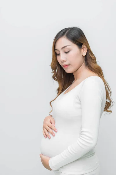 A pregnant woman in white dress stand pose for take a picture on white background