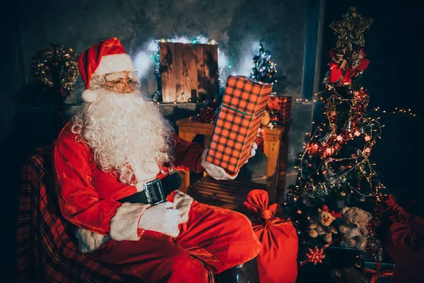 Santa claus holding gift box at home,Sit on chair think about plan for sent gift box for give children