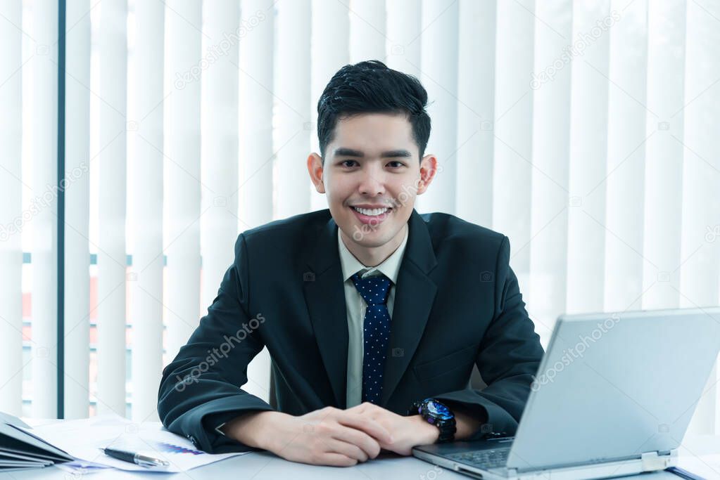 Young asian employee working at laptop during working day in office