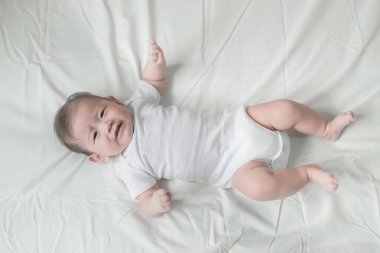 Closeup asian baby lying on the bed,Cute thailand little girl clipart