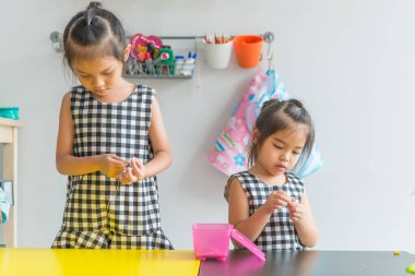 Sevimli küçük kız boncukları ipliyor ve bilezik yapıyor.