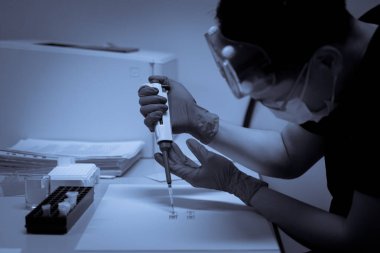 Asyalı bilim adamları plastik tüplere kimyasallar enjekte etti. Laboratuvarda çalışan Tayland 'lı bilim adamı. Laboratuvarda deneyler yaptı.