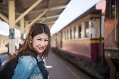 Asyalı turist tren istasyonunda bekler, Taylandlı hippi gezmeye gider.