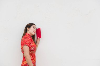 Mutlu Çin yeni yılı. Asyalı kadın portresinin beyaz duvarında kırmızı bir zarf var.