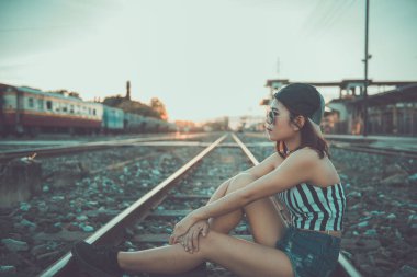 Hippi kız demiryolunda üzgün hissediyor Japon tonu, klasik stil, koyu ton, film, pastel