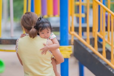 Güzel, genç bir anne kızınla oyun bahçesinde eğleniyor. Anneler günün kutlu olsun Tayland halkı.