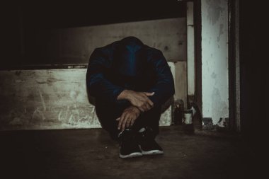 Asyalı üzgün bir adamın portresi, yerde oturan uyuşturucu bağımlısı, flakka ilacı, zombi uyuşturucusu