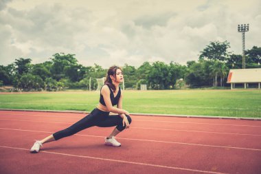 Asyalı zayıf kadın sabah antrenmanından önce ısınıyor, zayıf kız yaşam için egzersiz yapıyor, seçici odaklanma, parlak güneş ışığı, Taylandlılar...