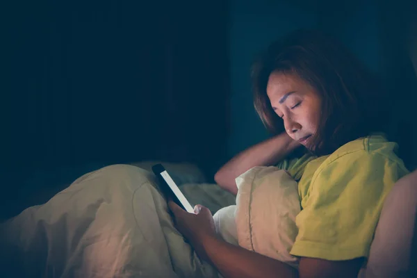 Asian woman play smartphone in the bed at night,Thailand people,Addict social media,Play internet all night