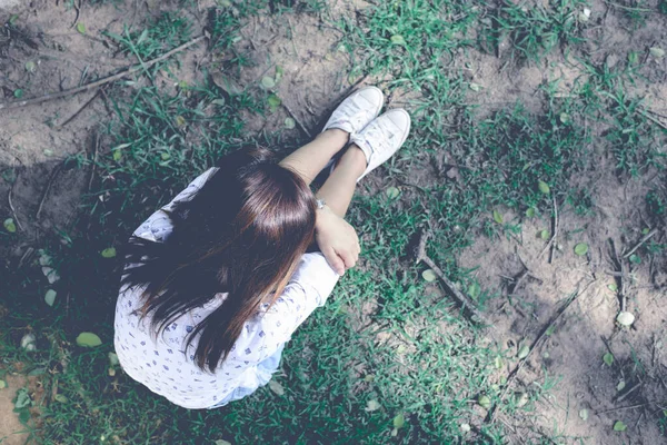 芝生の上に座って美しいアジアの女の子 緑のトーン クールなトーンを伸ばし — ストック写真