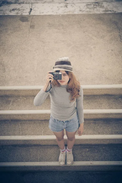 Asian hipsters girl with black camera action take a photo vintage style