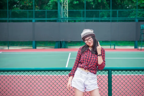 希斯特亚洲女孩摆姿势拍照 网球场上的时尚女人像 现代少女泰国人的生活方式 露出中指 — 图库照片