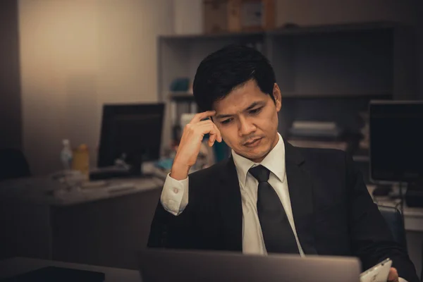 Businessman stress from hard work on the desk at office dark tone