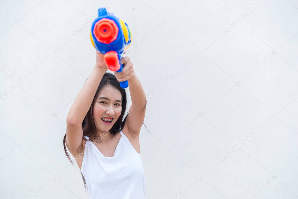 Asian woman with water gun in hand on white background, Festival songkran day in Thailand