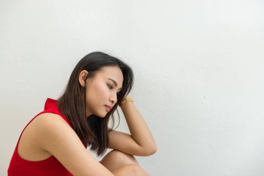 Kırmızı elbiseli güzel Asyalı kadın beyaz arka planda üzgün, gülümseyen zayıf kız, üzgün kadın konsepti