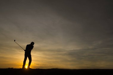 Siluet Asyalı golfçü güzel günbatımında golf oynuyor