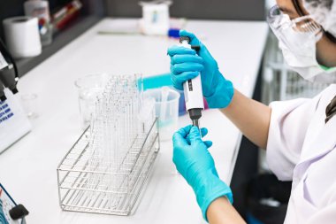 Asyalı bilim adamları plastik tüplere kimyasallar enjekte etti. Laboratuvarda çalışan Tayland 'lı bilim adamı. Laboratuvarda deneyler yaptı.