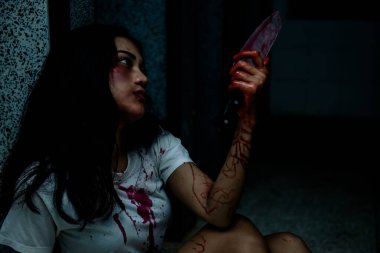 Elinde bıçak tutan güzel Asyalı kadın, cinayet konsepti, vücutta kan.