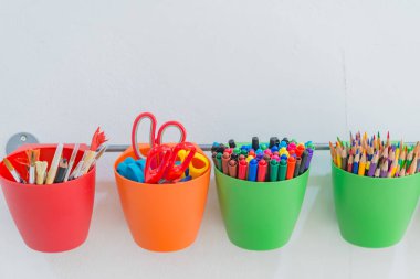 Silindir duvarda bir sürü kalem rengi asılı.