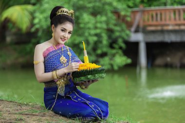 Tayland elbisesi içindeki güzel Asyalı kadın portresi geleneksel dua Kratong 'u, Tayland' da düzenlenen loy kratong festivaline katılması için tutuyor.
