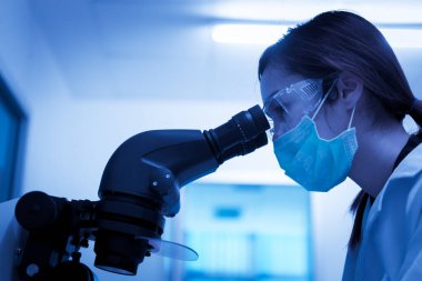 Laboratuvarda çalışan bayan Asyalı bilim adamı müşteri için formül kullanarak deney yapıyor.