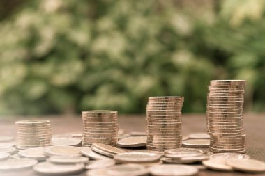 Tahta arka planda büyüyen para yığını grafiği, parlak güneş ışığı