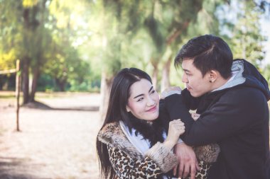 Parkta güneşli bir günde genç bir çiftin portresi, Sevgililer Günü konsepti