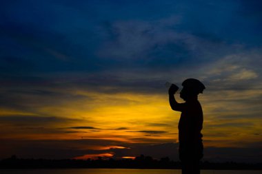Gün batımında bisikletli Asyalı yakışıklı bir siluet.
