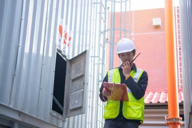 Büyük bir fabrikanın atık su yönetim sisteminde Asya Bakım Mühendisi, Tayland 'daki ısıtma sistemi ekipmanlarının teknik verilerini kontrol ediyor.