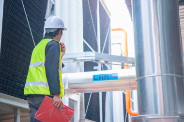 Büyük bir fabrikanın atık su yönetim sisteminde Asya Bakım Mühendisi, Tayland 'daki ısıtma sistemi ekipmanlarının teknik verilerini kontrol ediyor.