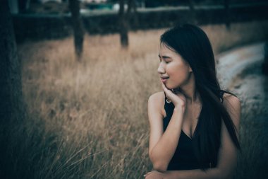 Tarlada yapayalnız bir kadının portresi. Klasik filtre stili. Aşktan kalbi kırık, günbatımı tarzında üzgün kız konsepti.