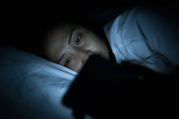 Asian woman play smartphone in the bed at night,Thailand people