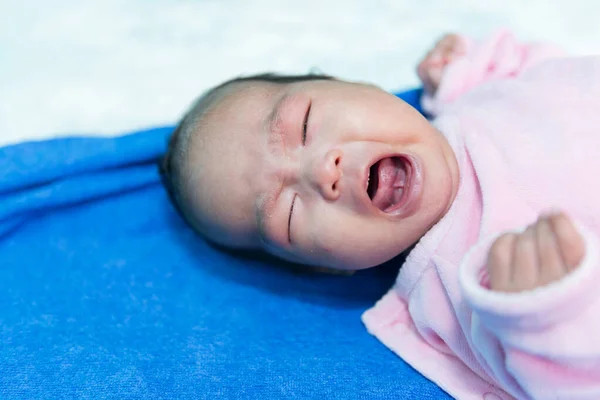 Close up asian baby girl cry on white wool carpet